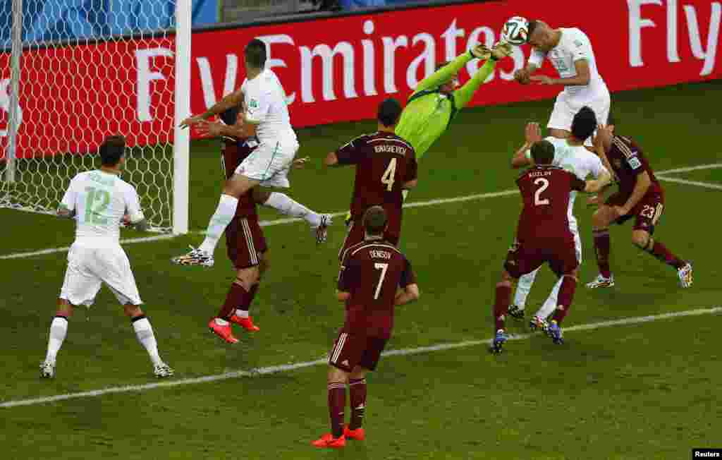 Algeria's Islam Slimani scores past Russia's goalkeeper Igor Akinfeev at the Baixada arena in Curitiba, June 26, 2014.