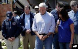 Vice President Mike Pence, center, and other bow their heads as his wife, Karen prays during a visit to the First Baptist Church of Rockport, Aug. 31, 2017, in Rockport, Texas. The church received heavy damage from Hurricane Harvey.
