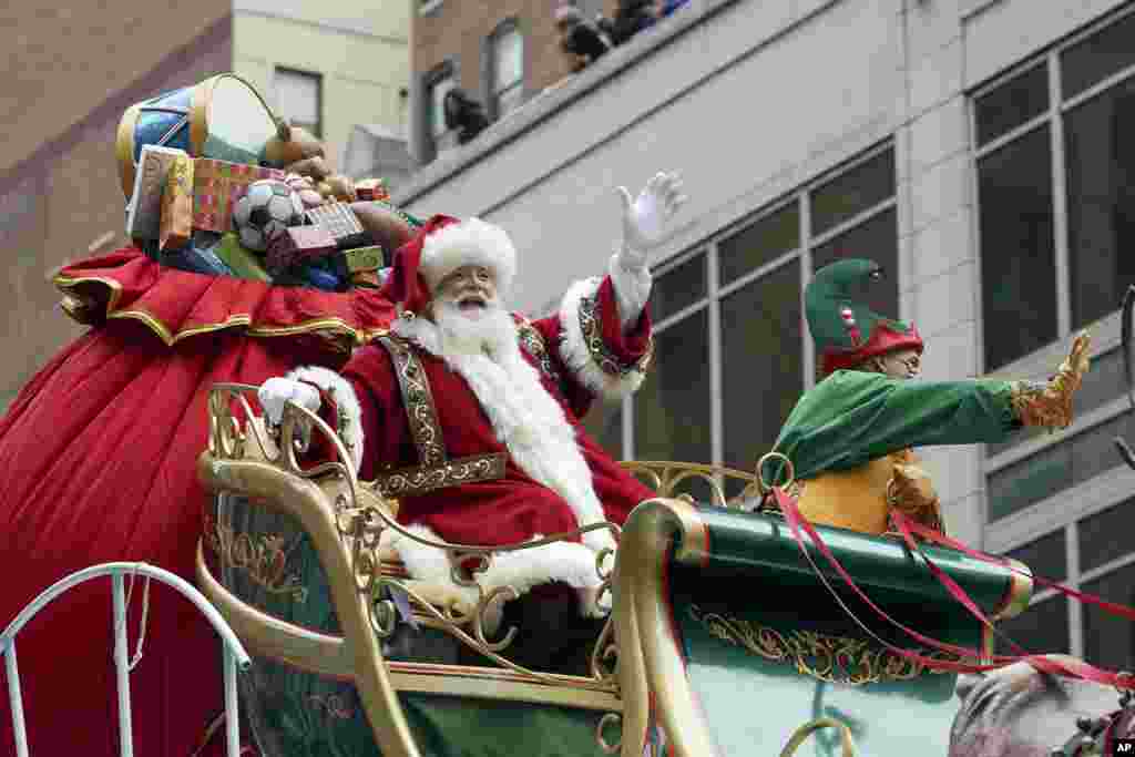 Santa Claus waves from atop a float while riding along 6th Ave. during the Macy&#39;s Thanksgiving Day Parade in New York.