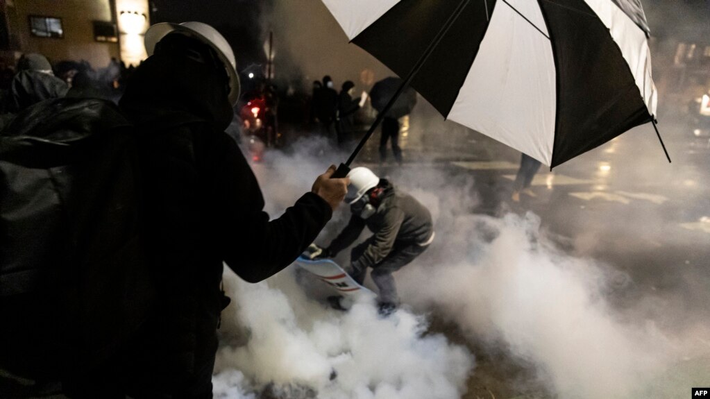 在明尼苏达州布鲁克林中心警察局外，人们躲避警方向抗议人群释放的催泪瓦斯。当地警察开枪打死一名黑人男子，引发了抗议。(2021年4月12日)(photo:VOA)