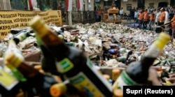 Petugas memusnahkan botol miras yang disita dari toko-toko pinggir jalan di Jakarta 29 Agustus 2008. (Foto: REUTERS/Supri)