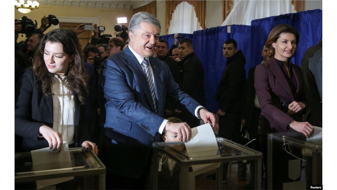 Ukraine's President and presidential candidate Petro Poroshenko and his family members, wife Maryna, daughter Yevhenia and grandson Petro, cast ballots at a polling station, March 31, 2019.