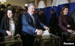 Ukraine's President and presidential candidate Petro Poroshenko and his family members, wife Maryna, daughter Yevhenia and grandson Petro, cast ballots at a polling station, March 31, 2019.