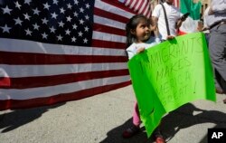 Maria Arellano, who works in Washington and whose parents are from Mexico, carries a sign during a Day Without Immigrants protest in Washington. (AP Photo/Alex Brandon)