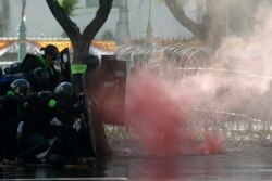 Riot police launch tear gas to protesters marching to Government House in Bangkok, Thailand Sunday, July 18, 2021.