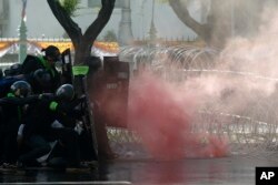 Riot police launch tear gas to protesters marching to Government House in Bangkok, Thailand Sunday, July 18, 2021.