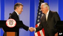 Colombia's President Juan Manuel Santos, left, shakes hands with U.S. Secretary of State Rex Tillerson during a joint press conference after a meeting at the presidential palace in Bogota, Colombia, Tuesday, Feb. 6, 2018.