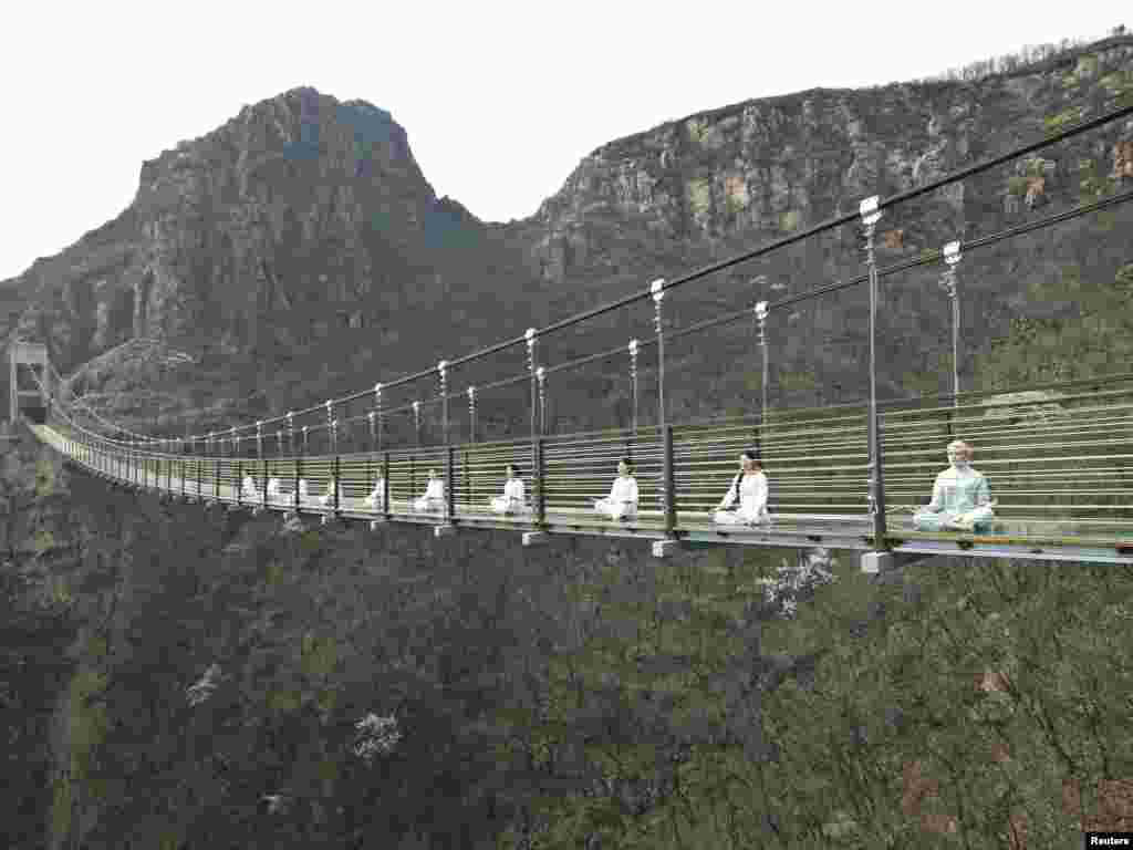 Women perform yoga on a glass suspension bridge in Fuxishan, Zhengzhou, Henan province, China, March 30, 2016.