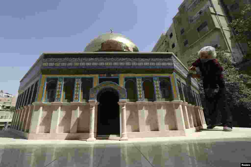 Jordanian artist Nezam Nimeh, 58, cleans his artwork which is a scale model of the Dome of the Rock in Amman.