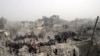 This citizen journalism image from the Aleppo Media Center (AMC) shows people searching debris of destroyed buildings after Syrian government forces airstrike, Jabal Bedro, Aleppo, Feb. 19, 2013.