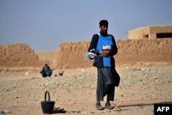 A deminer in Nad-e-Ali village in Helmand province takes a break to pray before resuming his dangerous work of removing unexploded ordnance.