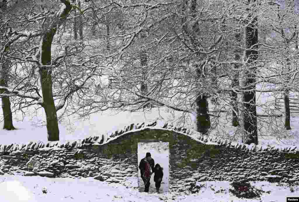 영국 뉴타운 린포트 시 브라드게이트 공원에서 한 남성과 어린아이가 눈 쌓인 공원을 걷고 있다.