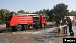 Afghan fire-fighters clean the site of a suicide attack in Kabul, Afghanistan, June 20, 2016.