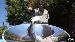 The photo is of SunFire's solar energy expert, Zander van Manen, cooking on a parabolic solar dish, Johannesburg, South Africa. (Darren Taylor/VOA)