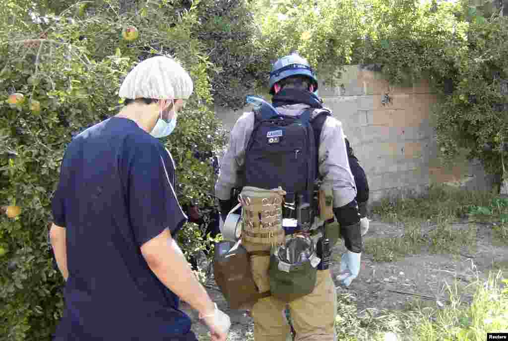 A U.N. chemical weapons expert gathers evidence at site of an alleged poison gas attack in a southwestern Damascus suburb, August 26, 2013. 
