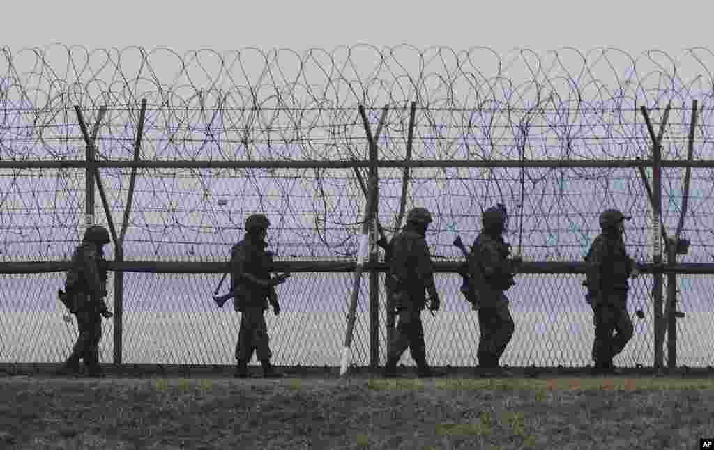 South Korean army soldiers patrol along a barbed-wire fence near the border village of the Panmunjom, in Paju, South Korea, April 8, 2013.