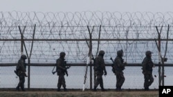 S. Korean army soldiers patrol along a barbed-wire fence near the border village of the Panmunjom, in Paju, April 8, 2013. 