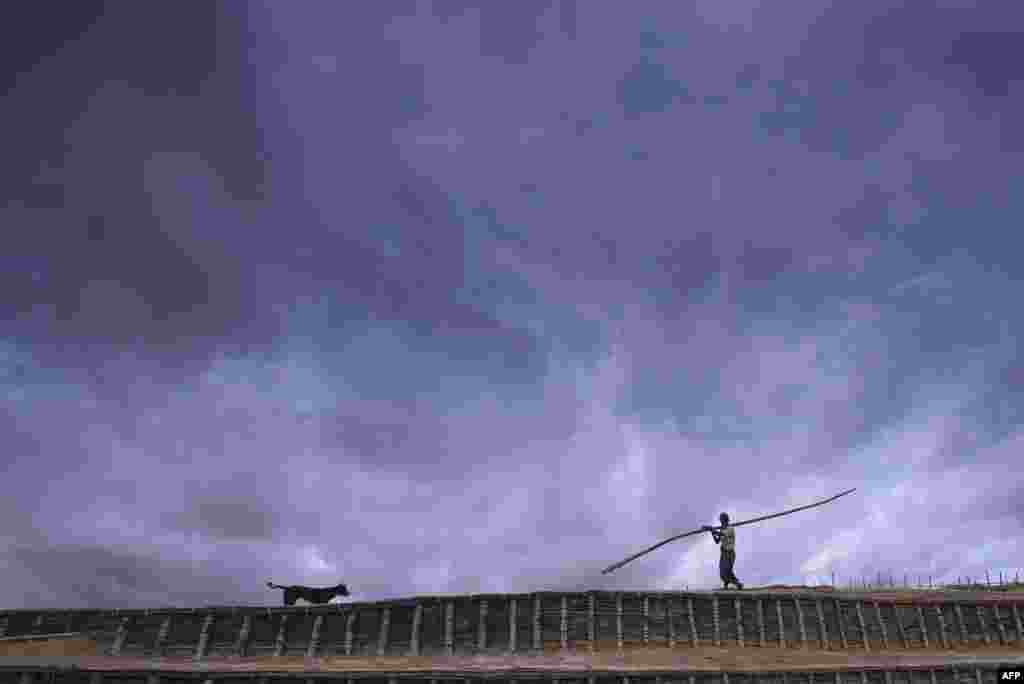 A Rohingya man carries a bamboo pole at Kutupalong refugee camp in Ukhia, Bangladesh.