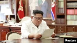 Severnokorejski lider Kim Džong Un čita pismo predsednika SAD Donalda Trampa, u Pjongjangu, Severna Koreja, na fotografiji koju je objavila severnokorejska Kojrejska centralna novinska agecija 22. juna 2019.