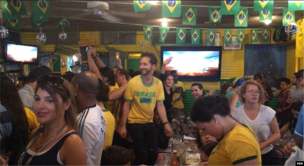 Para penggemar sepakbola memadati klub Little Favela di Brooklyn, New York, untuk menonton pertandingan pertama Piala Dunia 2014 (12/6). (VOA/Adam Phillips)
