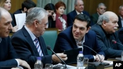 Greece's Prime Minister Alexis Tsipras, second right, and Deputy Prime Minister Giannis Dragasakis, second left, chat during the first cabinet meeting of the new government at the Parliament in Athens, on Wednesday, Jan. 28, 2015.