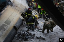 Nepalese rescuers work amid the debris after a passenger plane from Bangladesh crashed at the airport in Kathmandu, Nepal, March 12, 2018.