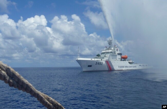 FILE - A Chinese Coast Guard boat approaches a Filipino fishing vessel off Scarborough Shoal in the South China Sea, Sept. 23, 2015.