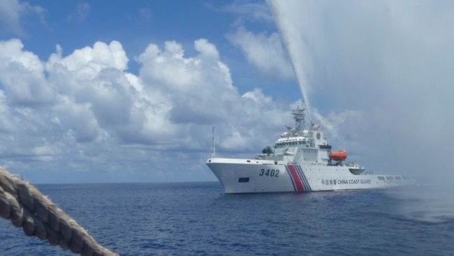 资料照片:一艘中国海警船驶近在南中国海斯卡伯勒礁(黄岩岛)附近捕鱼的菲律宾渔船。 (2015年9月23日)