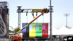 Workers hang signs in preparation for the New Orleans Jazz and Heritage Festival in New Orleans, April 28, 2011