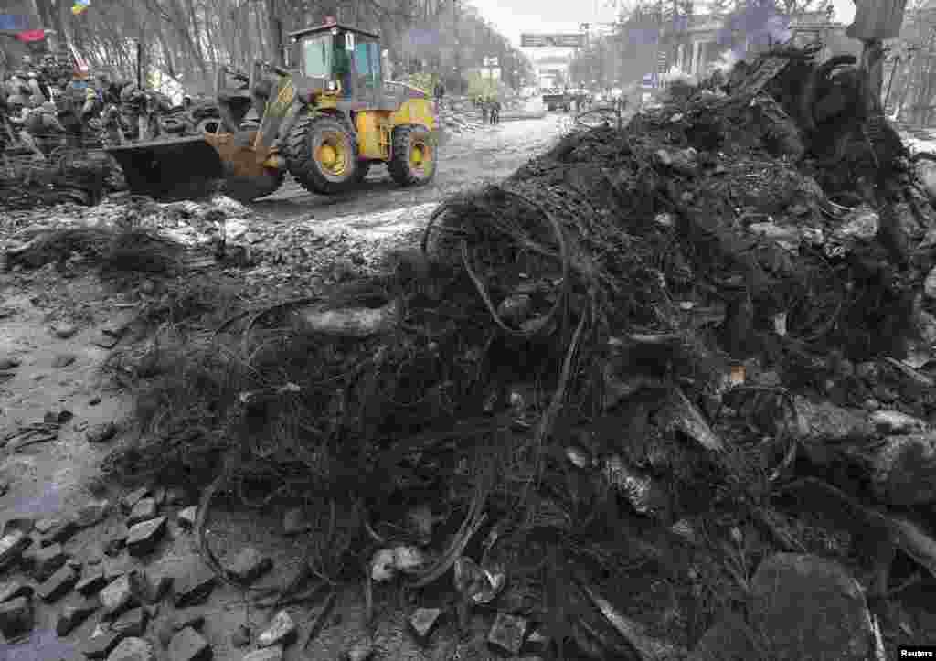 A bulldozer plows away barricades at the site of recent clashes with riot police in Kyiv, Feb. 16, 2014.&nbsp;
