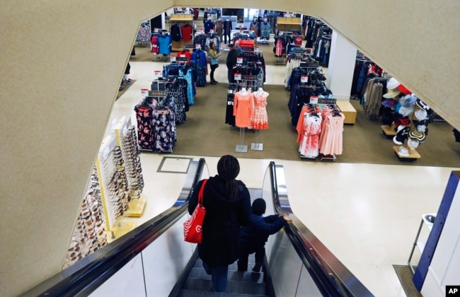 In this March 22, 2017, file photo, a woman and child ride the escalator at a Sears store in St. Paul, Minnesota.