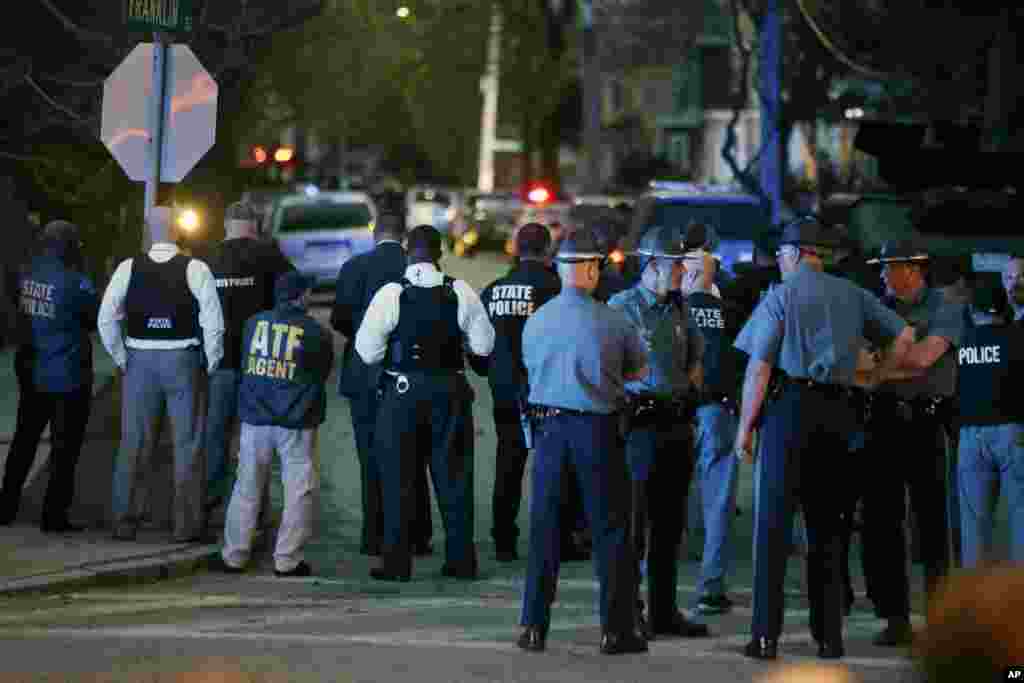 Officers look on as the search for a suspect in the Boston Marathon bombings continues, April 19, 2013, in Watertown, Massachusetts. 