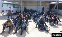 Migrants are seen at a naval base after being rescued by the Libyan coast guard in Tripoli, Libya, March 10, 2018. Several boats were intercepted Saturday between Libya and Italy.