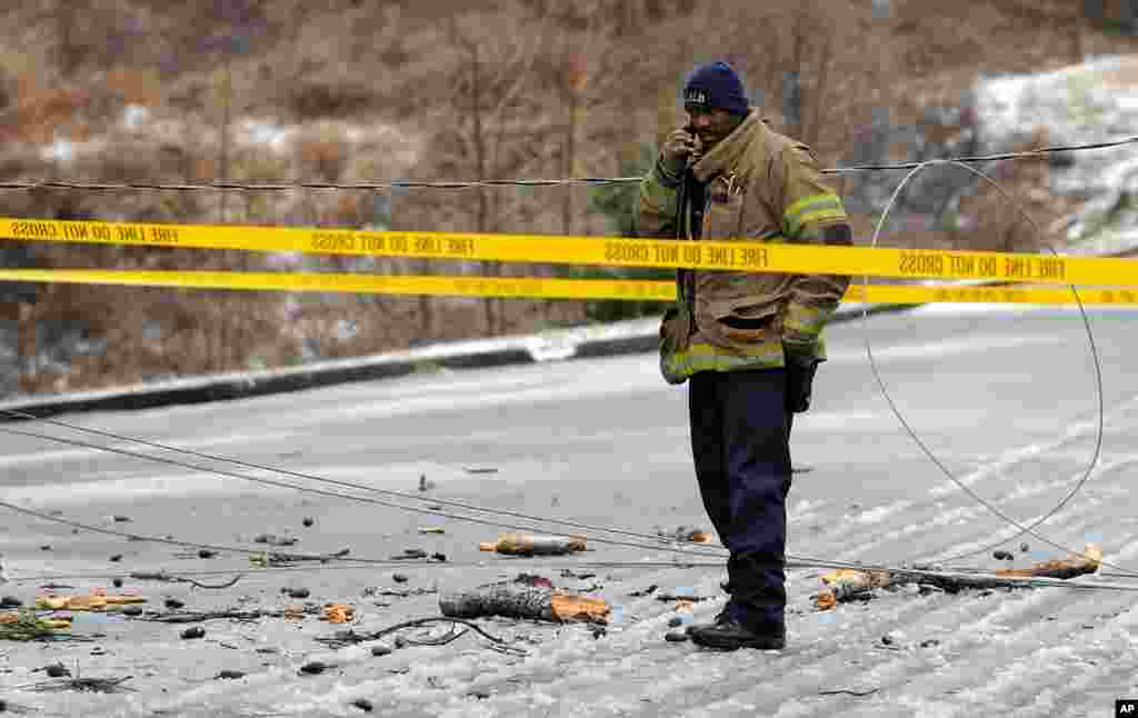 Petugas darurat mengamankan kabel listrik yang jatuh di Atlanta, Georgia, 12 Februari 2014.