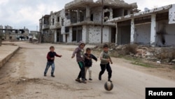 Trẻ em Syria chơi gần các tòa nhà bị hư hại tại thị trấn lịch sử ở miền nam do phiến quân kiểm soát là Bosra al-Sham, Deraa.