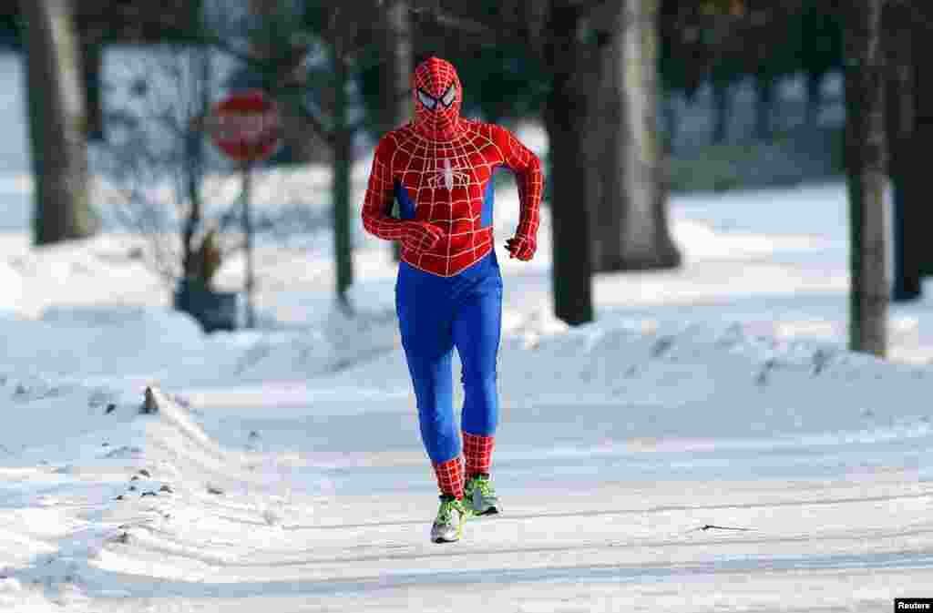 Patrick O'Brien in a Spiderman wind suit jogs around Lake Harriet in south Minneapolis, Minnesota, USA. A blast of Arctic air gripped the mid-section of the U.S., bringing the coldest temperatures in two decades, forcing businesses and schools to close and causing widespread airline delays and hazardous driving conditions.