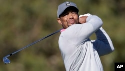 Tiger Woods watches his tee shot on the ninth hole of the North Course during the second round of the Farmers Insurance Open golf tournament, Jan. 27, 2017, at Torrey Pines Golf Course in San Diego.