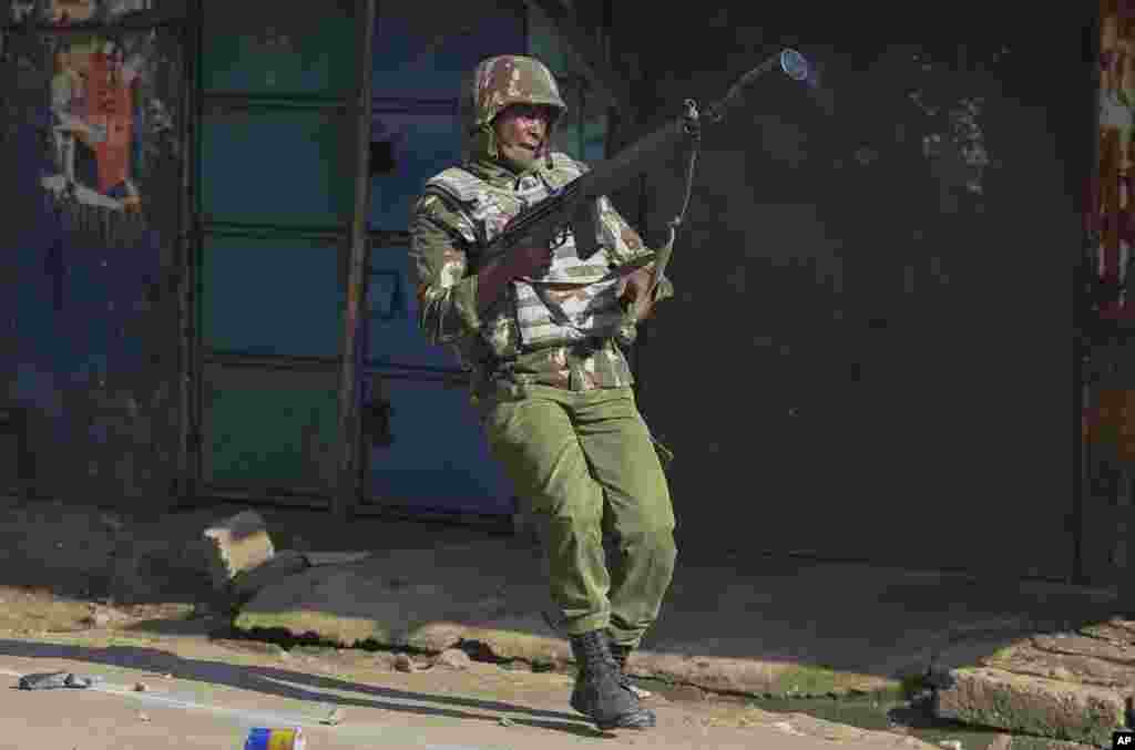 A riot policeman with a tear gas gun during clashes with opposition supporters in Mathare slums in Nairobi, Kenya.
