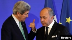 French Foreign Affairs Minister Laurent Fabius (R) listens to U.S. Secretary of State John Kerry after a news conference at the ministry in Paris, Feb. 27, 2013. 