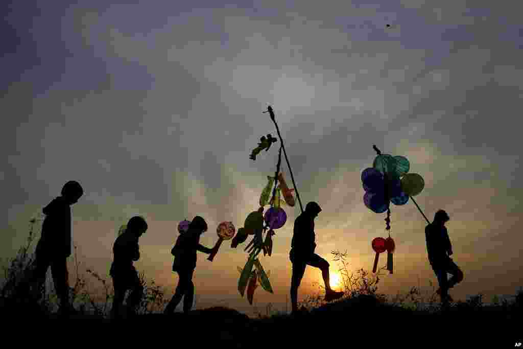 Indian balloon vendors walk back home as the sun sets on New Year&#39;s Eve in Jammu, India.