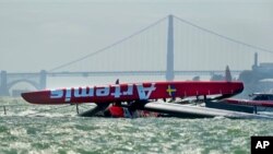 Perahu layar catamaran "The Artemis Racing AC72", peserta lomba Piala Amerika dari Swedia, terbalik saat latihan di lepas pantai San Francisco, Kamis (9/5). Atlet Inggris Peraih medali emas Olimpiade Beijing 2008, Andrew "Bart" Simpson, emas Olimpiade peraih medali dari Inggris, meninggal dunia setelah terjebak di bawah perahu terbalik tersebut selama 10 menit. Jembatan "Golden Gate", yang identik dengan kota San Francisco tampak sebagai latar belakang foto ini. (AP Photo / Noah Berger)