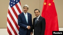 U.S. Secretary of State John Kerry shakes hands with Chinese Foreign Minister Wang Yi during, ASEAN Regional Forum, Myanmar International Convention Centre, Naypyitaw, Aug. 9, 2014.
