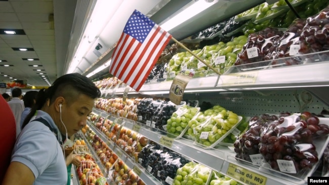 Một người mua hàng tại một siêu thị ở Hà Nội bên các sản phẩm hoa quả nhập khẩu từ Mỹ. Hàng hóa Mỹ nhập khẩu vào Việt Nam đã tăng mạnh trong 6 tháng đầu năm nay do thương chiến Mỹ-Trung.