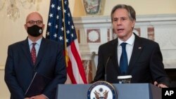 Secretary of State Antony Blinken speaks at the State Department in Washington, Nov. 5, 2021, as Jonathan Moore listens. Moore has been appointed to be the State Department's new coordinator for its investigation into cases of so-called Havana Syndrome. 