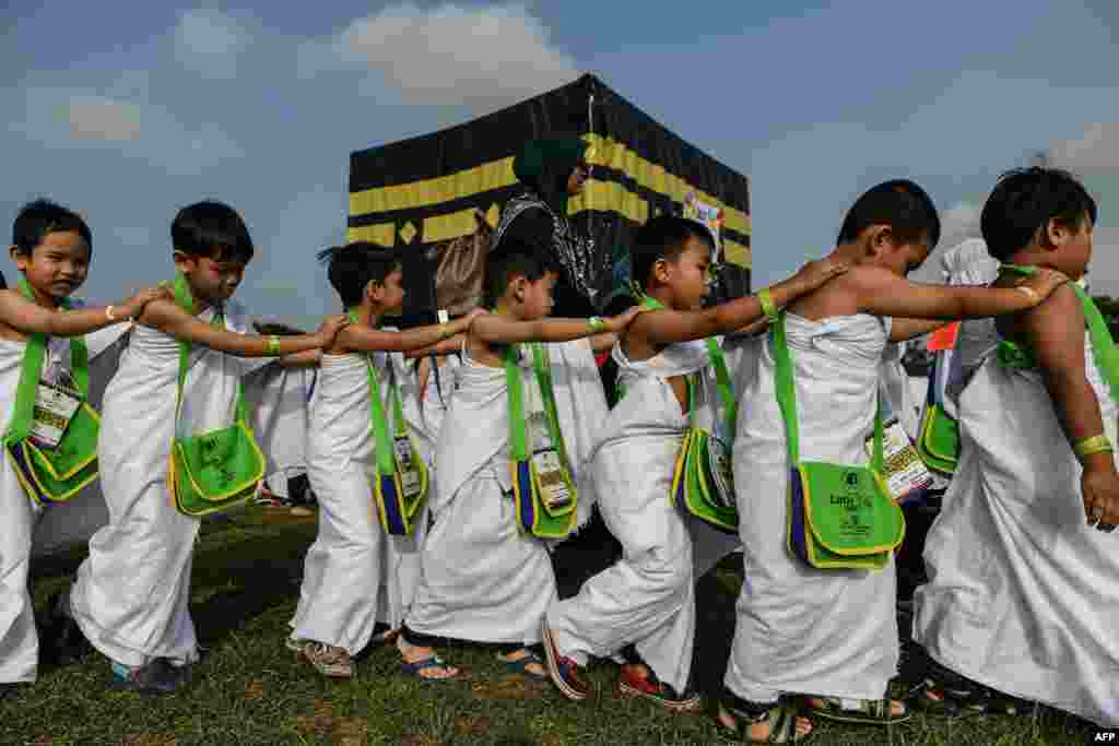 Ihram-clad Malaysian Muslim boys circumambulate a mockup of the Kaaba, Islam&#39;s most sacred structure located in the holy city of Mecca, during an educational simulation of the Hajj pilgrimage.