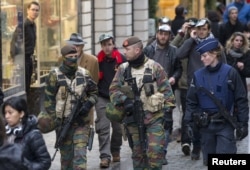 Belgian soldiers and police patrol on Brussels Grand Place after security was tightened in Belgium following the fatal attacks in Paris last week, in Brussels, Belgium, Nov. 20, 2015.