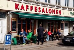 Orang-orang duduk di Kaffesalonen (The Coffee Saloon) saat pembatasan COVID-19 dilonggarkan, di pusat Kopenhagen, Denmark, 21 April 2021. (REUTERS/Tim Barsoe/File Photo)