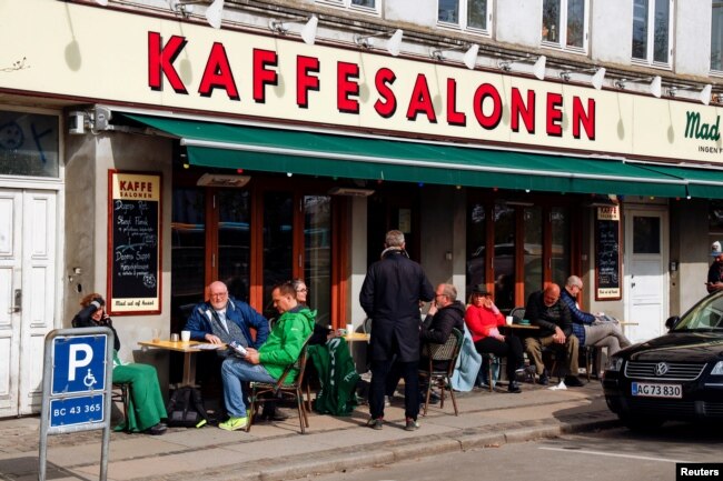 Orang-orang duduk di Kaffesalonen (The Coffee Saloon) saat pembatasan COVID-19 dilonggarkan, di pusat Kopenhagen, Denmark, 21 April 2021. (REUTERS/Tim Barsoe/File Photo)