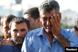 Omar Al-Zuhbe, right, father of Belal Al-Zuhbe, one of the solders killed in an attack on a border military post near a camp for Syrian refugees, cries during his son's funeral in Jerash, north of Amman, Jordan, June 21, 2016.