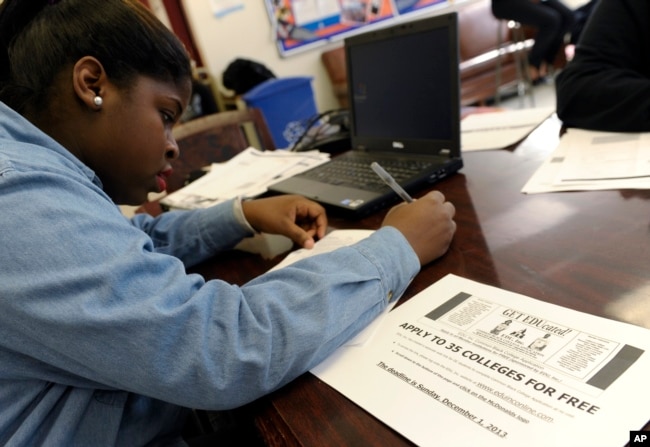 FILE - A senior at Roosevelt High School in Washington, D.C., fills out a college application.